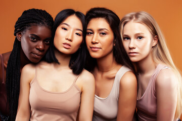 young pretty asian, caucasian, afro woman posing cheerful together on brown background, lifestyle diverse nationality people concept