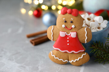 Wall Mural - Gingerbread girl on grey marble table, closeup. Space for text