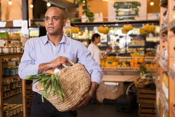 Shopper with bag of groceries and vegetables at grocery supermarket