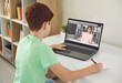 © Studio Romantic - Boy pupil sitting at home and making notes during online lesson