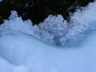 stunning frozen icicles waterfall on a rocky mountain cliff on a winter day. the winter cascade is f