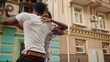 Emotional guy and girl rotating in dance in city. Couple dancing outdoors