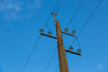 old concrete electric pole with wires and blue sky