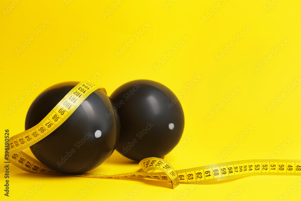 Air balloons and measuring tape on color background. Breast augmentation concept