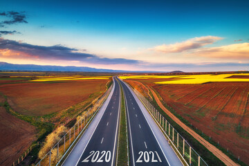 Wall Mural - Aerial view of highway on sunset. Transportation background. Landscape with road near countryside fields