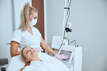 Wall Mural - Dermatologist touching the screen of a beauty machine