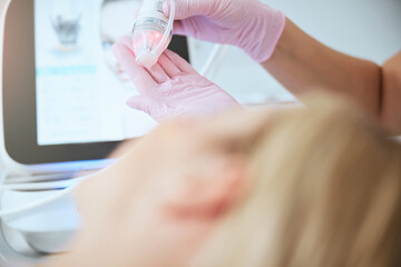 Wall Mural - Female doctor preparing the fractional microneedle machine for work