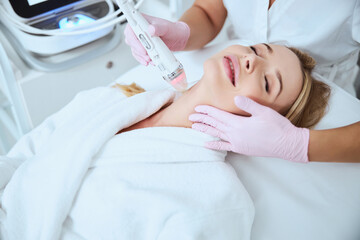 Wall Mural - Woman being treated for fine lines on her neck