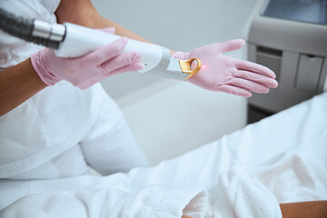 Wall Mural - Dermatologist testing the beauty device before the procedure