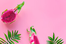 Fresh Organic Pink Dragon Fruit, Pitaya Or Pitahaya With Pink Middle Cut In Half. Panoramic Image On Pink Background With Palm Leaves, Copy-space..