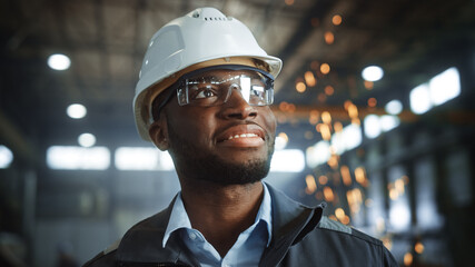 Aufkleber - Happy Professional Heavy Industry Engineer/Worker Wearing Uniform, Glasses and Hard Hat in a Steel Factory. Smiling African American Industrial Specialist Standing in a Metal Construction Manufacture.