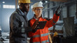© Gorodenkoff - Two Heavy Industry Engineers Stand in Steel Metal Manufacturing Factory, Use Digital Tablet Computer and Have a Discussion. Black African American Industrial Specialist Talk to Female Technician.