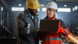 © Gorodenkoff - Two Heavy Industry Engineers Stand in Steel Metal Manufacturing Factory, Use Digital Tablet Computer and Have a Discussion. Black African American Industrial Specialist Talk to Female Technician.