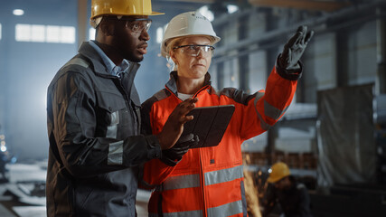 Aufkleber - Two Heavy Industry Engineers Stand in Steel Metal Manufacturing Factory, Use Digital Tablet Computer and Have a Discussion. Black African American Industrial Specialist Talk to Female Technician.