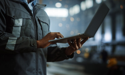 Aufkleber - Close Up on Hands of a Professional Heavy Industry Engineer Wearing Safety Uniform and Using Laptop Computer. African American Industrial Specialist Standing in a Metal Construction Manufacture.