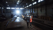 © Gorodenkoff - Two Heavy Industry Engineers Walk in Steel Metal Manufacturing Factory, Use Digital Tablet Computer and Have a Discussion. Black African American Industrial Specialist Talk to Female Technician.