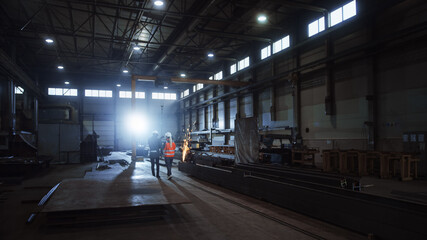Aufkleber - Two Heavy Industry Engineers Walk in Steel Metal Manufacturing Factory, Use Digital Tablet Computer and Have a Discussion. Black African American Industrial Specialist Talk to Female Technician.