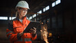 © Gorodenkoff - Professional Heavy Industry Engineer/Worker Wearing Safety Uniform and Hard Hat Uses Tablet Computer. Serious Successful Female Industrial Specialist Standing in a Metal Manufacture Warehouse.