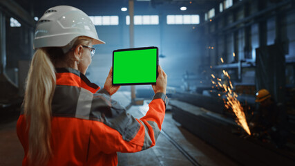 Aufkleber - Professional Heavy Industry Engineer Uses Tablet Computer with Green Screen Mock Up Display. Female Industrial Specialist Working in a Metal Manufacture Warehouse with Sparks in the Background.