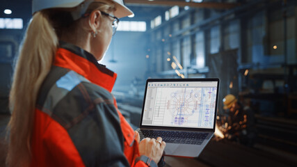 Aufkleber - Professional Heavy Industry Engineer Uses Laptop Computer with CAD Software to Check Metal Gear Blueprints. Female Industrial Specialist Working in a Metal Manufacture Warehouse.