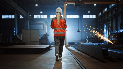 Aufkleber - Professional Heavy Industry Engineer/Worker Wearing Safety Uniform and Hard Hat Uses Tablet Computer. Serious Successful Female Industrial Specialist Walking in a Metal Manufacture Warehouse.