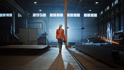 Aufkleber - Professional Heavy Industry Engineer/Worker Wearing Safety Uniform and Hard Hat Uses Tablet Computer. Serious Successful Female Industrial Specialist Walking in a Metal Manufacture Warehouse.