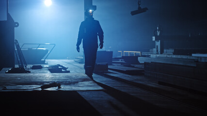 Wall Mural - Professional Heavy Industry Engineer/Worker Wearing Uniform, Flashlight on the Hard Hat in a Steel Factory. Industrial Specialist Walking Towards the Camera in a Dark Metal Construction Manufacture.