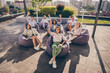 © deagreez - Portrait of nice cheerful entrepreneurs leaders partners sitting in bag chairs listening speaker company culture on roof outside outdoor