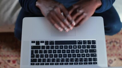 Poster - Hands of a black man during focus of attention of work in a laptop. He rubs them and kneads his fingers. Concentration of thoughts before typing text. Close-up.