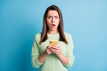 Wall Mural - photo portrait of upset woman holding yellow phone in two hands isolated on pastel blue colored back