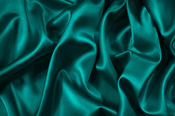 Wall Mural - Blue green silk satin fabric. Teal color elegant background. Liquid wave or silk wavy folds. Beautiful dark turquoise background with copy space for your design.