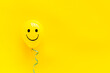 Happiness emotion face on balloon - joy mood background. Top view, copy space