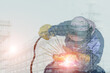 © TawanSaklay - Double exposure welder Industry worker at the factory welding steel structure on power plant background