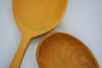 Two large Ukrainian wooden spoons are located on a white fabric background.