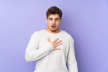 Wall Mural - Caucasian man isolated on purple background surprised and shocked while looking right