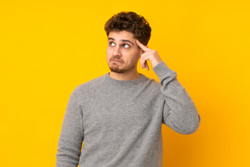 Wall Mural - Young caucasian man isolated background making the gesture of madness putting finger on the head