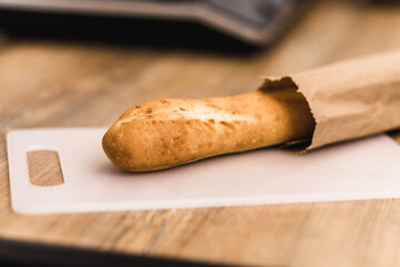 Photo of fresh baked bread lies on the table on a cutting board.