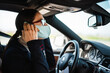 © Drobot Dean - Business woman sitting in a car in face mask