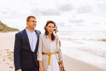 Happy just married middle age couple walk at beach and have fun on summer day.