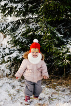 Little Girl Standing Near Snowy Spruce
