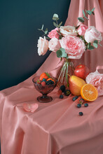 Fresh Berries, Pear, Apples, Orange And Flowers In A Vase On The Table