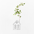 © Yaroslav Danylchenko/Stocksy - Sketch of house with branch of green leaves.