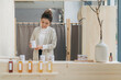 © Maki Company Limited/Stocksy - Young Japanese woman seller in uniform holding tea box