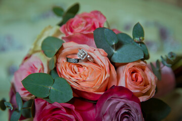 Wall Mural - Gold rings for a wedding on a bouquet of flowers. peach wedding rose bouquet . Bouquet of orange roses.