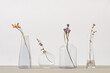 © Yaroslav Danylchenko/Stocksy - Dry flower twigs in a glass vases.