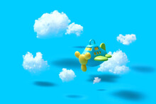 Flying Airplain Toy In A Blue Sky With Cotton Clouds.