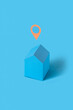 © Yaroslav Danylchenko/Stocksy - Blue colored papercraft house with location sign.