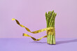 © Yaroslav Danylchenko/Stocksy - Flying measuring tape around asparagus banch.