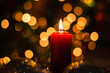 Candles and Christmas decorations on dark background with lights