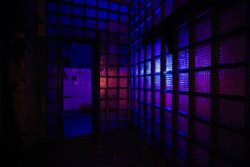 Glass block walls in old abandoned building, color illuminated